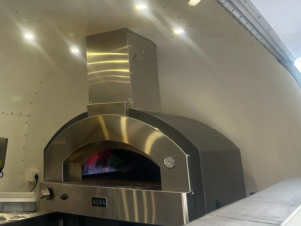 Loderndes Feuer im ALFA-Steinofen des Pizza di Angelo Pizzawagens
